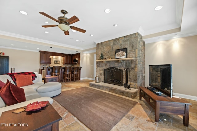 living room with a fireplace, ornamental molding, and ceiling fan