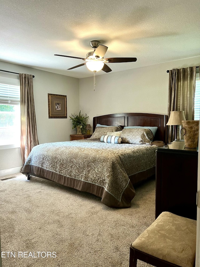 bedroom featuring a textured ceiling, ceiling fan, and carpet flooring