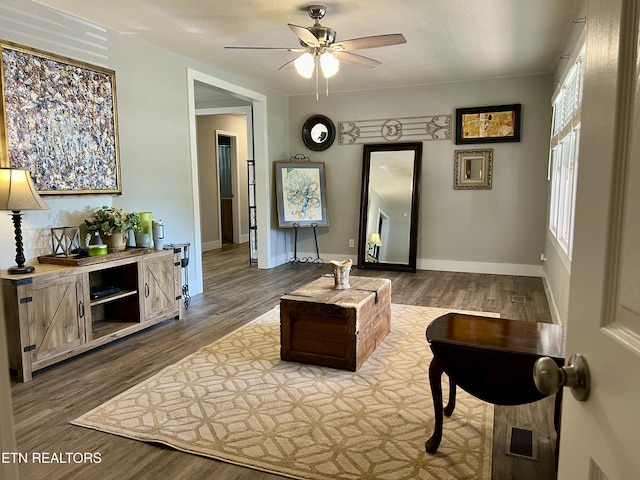 living room featuring ceiling fan, a textured ceiling, and hardwood / wood-style flooring