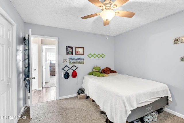 bedroom with a textured ceiling, ceiling fan, and carpet flooring