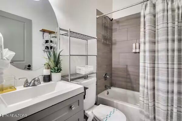 full bathroom featuring toilet, vanity, and shower / bath combo with shower curtain