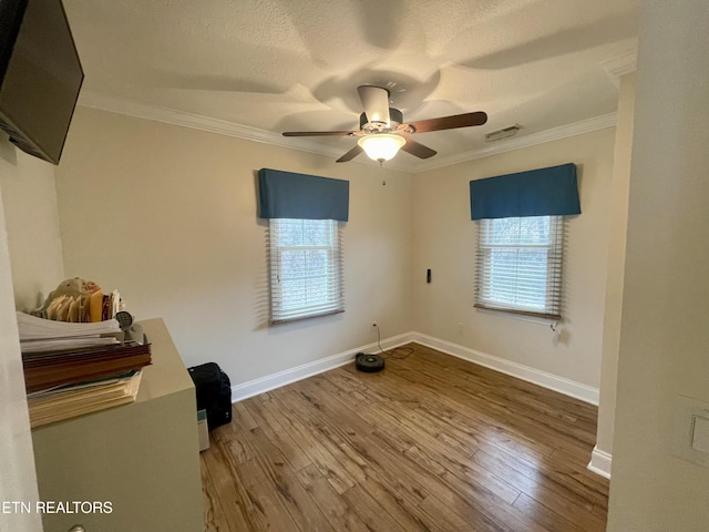 interior space featuring ceiling fan, wood-type flooring, and ornamental molding