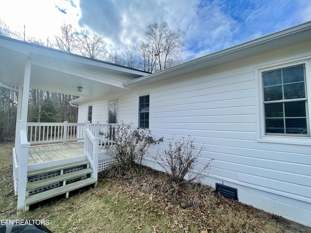 view of side of property featuring a wooden deck