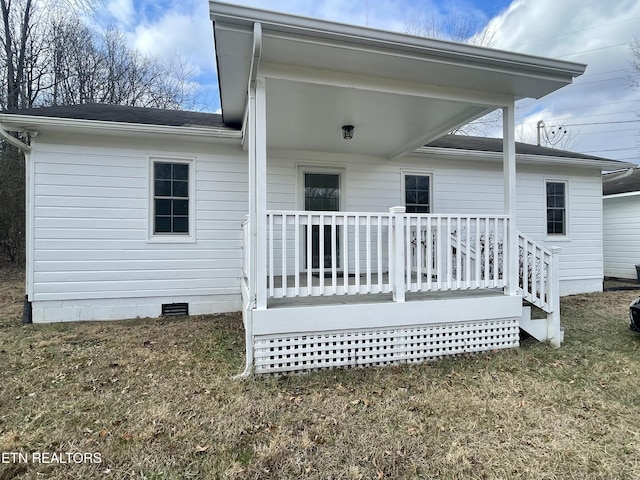 back of house featuring a wooden deck and a lawn