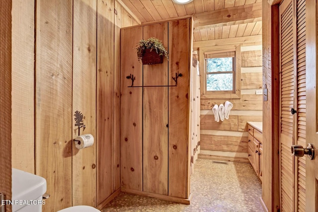 bathroom with toilet, vanity, wood ceiling, and wooden walls