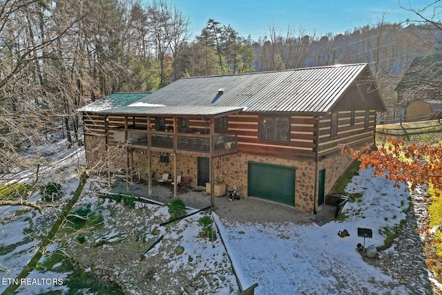 back of property featuring a garage and a wooden deck