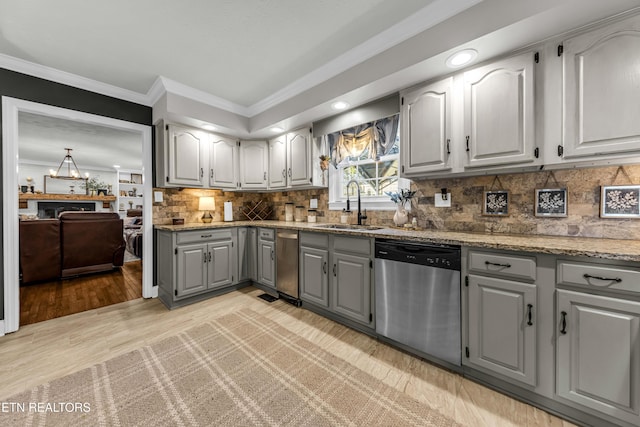 kitchen featuring dishwasher, decorative backsplash, sink, light hardwood / wood-style floors, and gray cabinetry