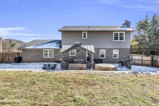 back of house featuring an outdoor living space with a fire pit and a lawn