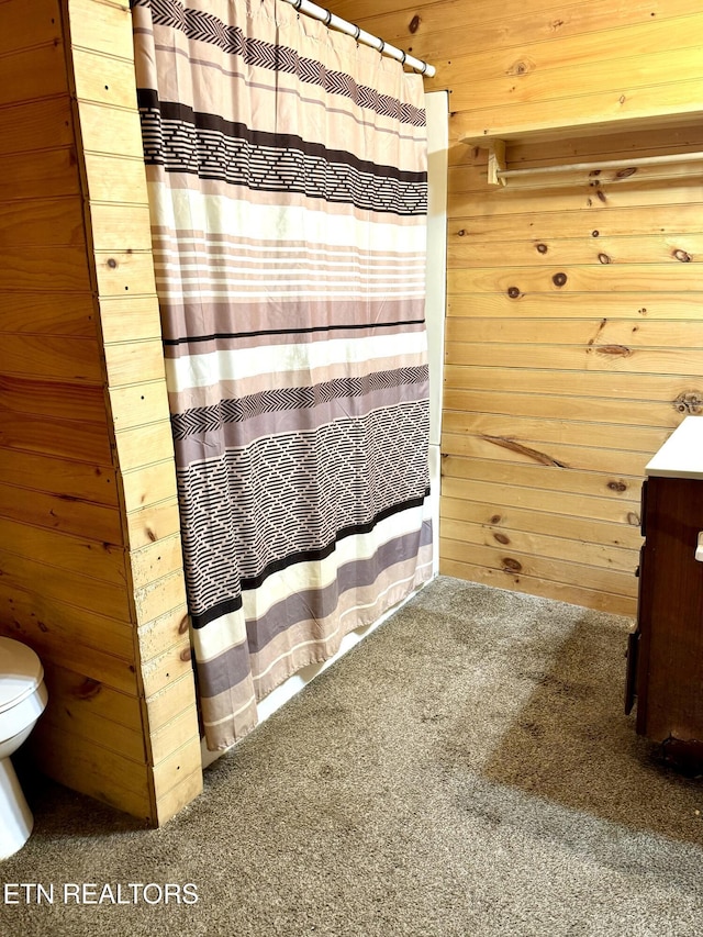 bathroom featuring toilet and wood walls