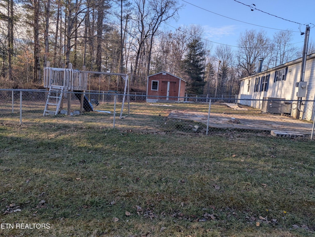 view of yard featuring a storage shed and a playground