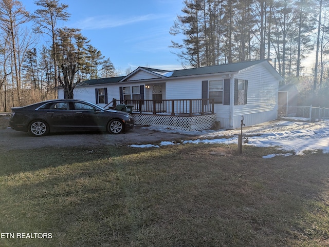 view of front of home featuring a front lawn and a wooden deck