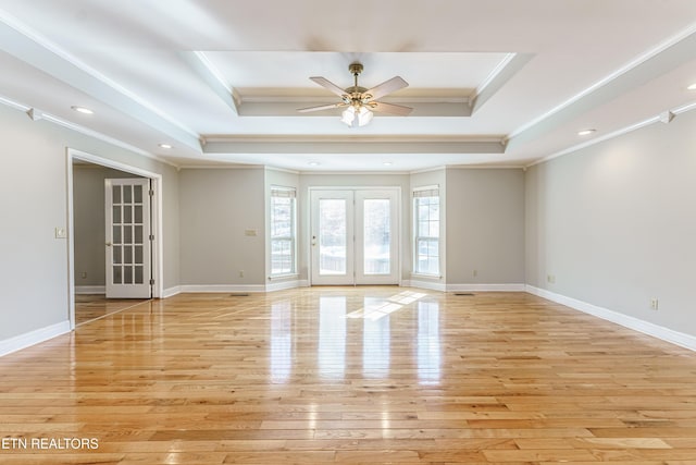 spare room featuring ornamental molding, a raised ceiling, and light hardwood / wood-style flooring