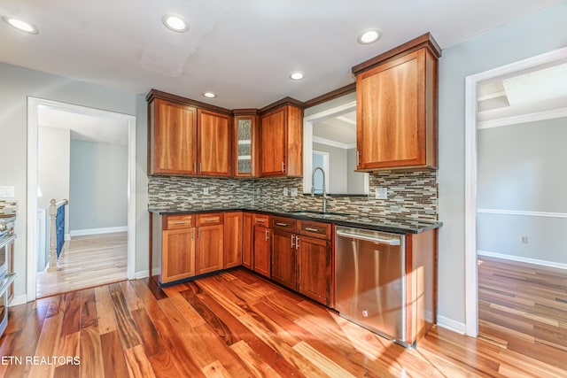 kitchen featuring tasteful backsplash, dishwasher, sink, and dark hardwood / wood-style flooring