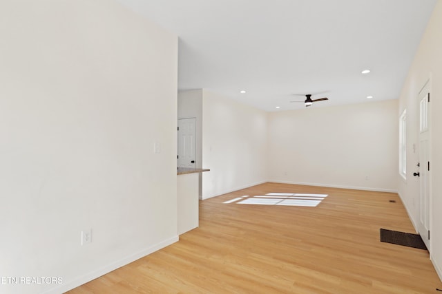 empty room with ceiling fan and light hardwood / wood-style floors