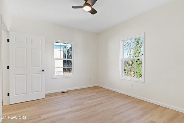 empty room featuring ceiling fan, light wood-type flooring, and plenty of natural light