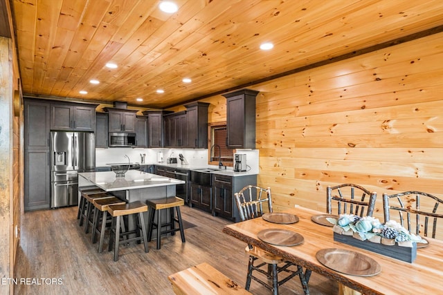 kitchen with dark hardwood / wood-style floors, a kitchen island, appliances with stainless steel finishes, wood ceiling, and dark brown cabinets