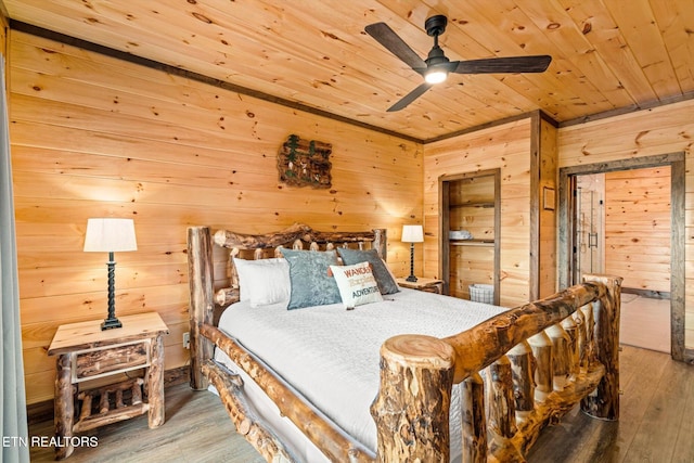 bedroom with wooden ceiling, hardwood / wood-style floors, wooden walls, and ceiling fan