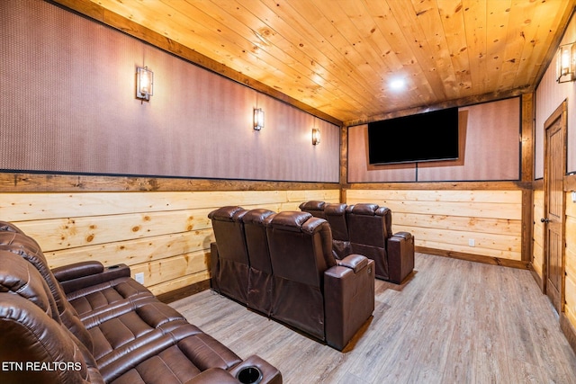 cinema featuring light wood-type flooring, wooden ceiling, and wooden walls