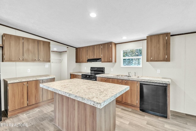 kitchen featuring lofted ceiling, sink, a center island, light hardwood / wood-style floors, and black appliances