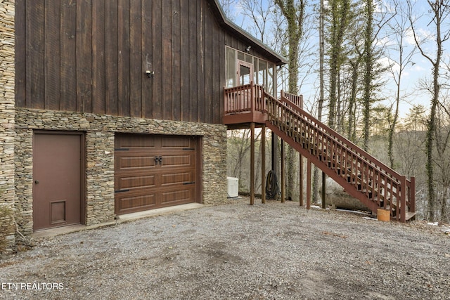 view of side of home featuring central AC unit and a garage