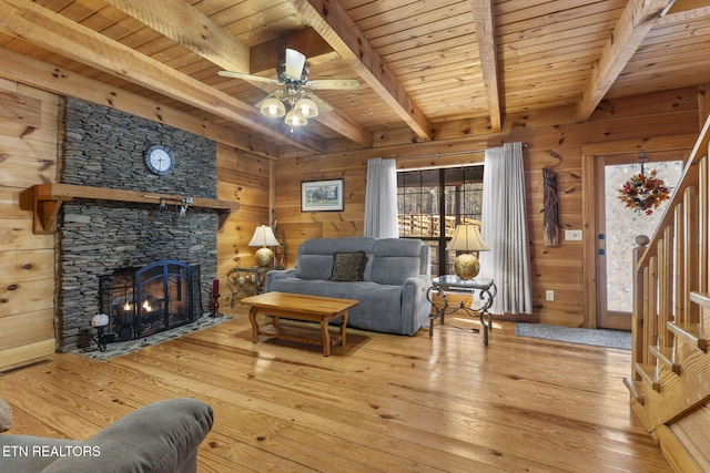 living room with beam ceiling, light wood-type flooring, and wooden ceiling