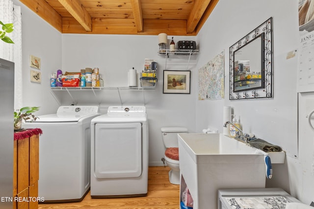 laundry area with wooden ceiling, washer and clothes dryer, and light wood-type flooring