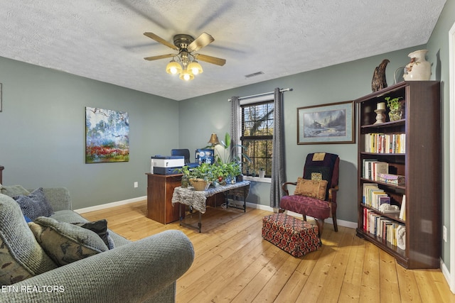 office space featuring ceiling fan, a textured ceiling, and light wood-type flooring