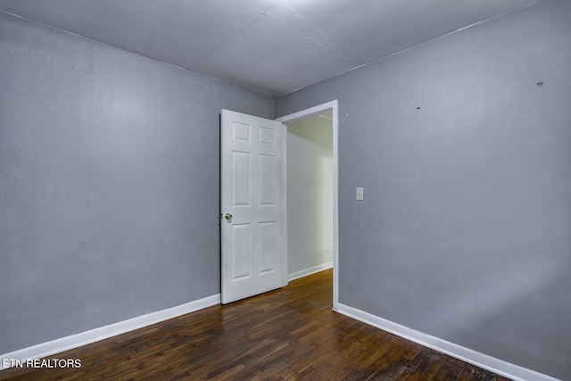 unfurnished room with dark wood-type flooring