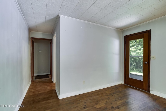 spare room featuring dark wood-type flooring and crown molding