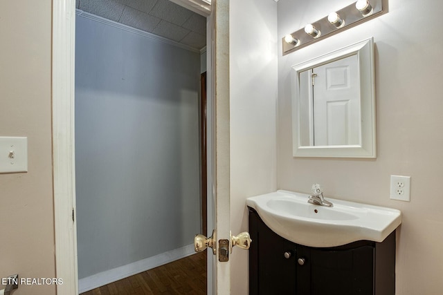 bathroom featuring ornamental molding, hardwood / wood-style floors, and vanity