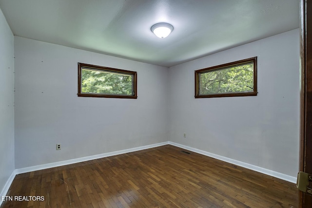 empty room with dark hardwood / wood-style floors