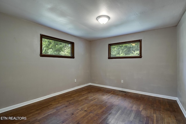 empty room with dark hardwood / wood-style flooring