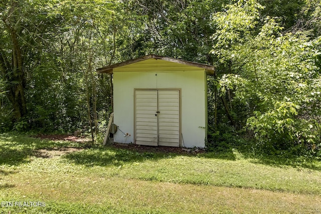 view of outbuilding featuring a lawn