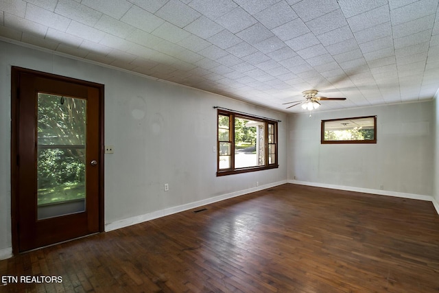 empty room with ceiling fan, dark hardwood / wood-style flooring, and crown molding