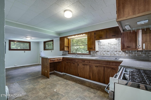 kitchen with gas stove, kitchen peninsula, and sink