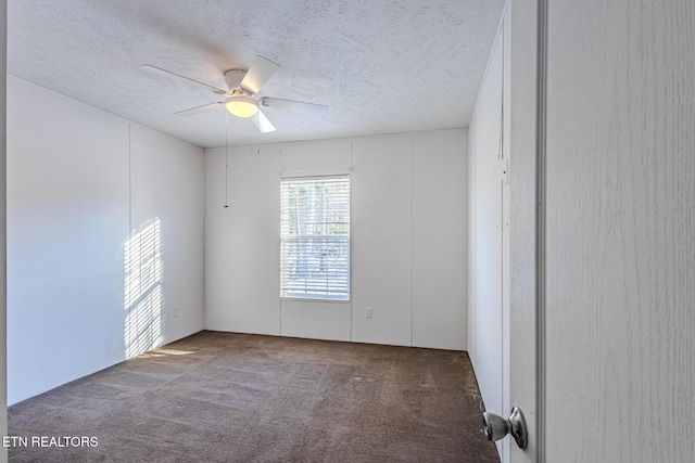 carpeted empty room with ceiling fan and a textured ceiling