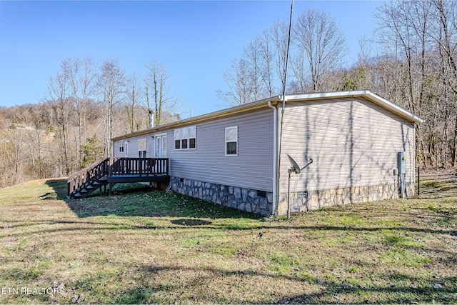 view of side of home with a yard and a deck