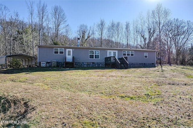 view of front facade featuring a carport, cooling unit, and a front lawn