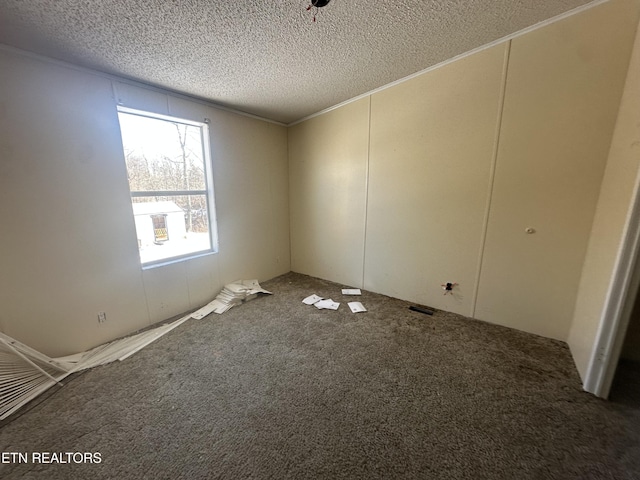 carpeted empty room with a textured ceiling