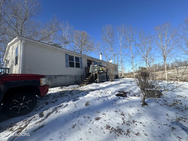 view of snow covered back of property