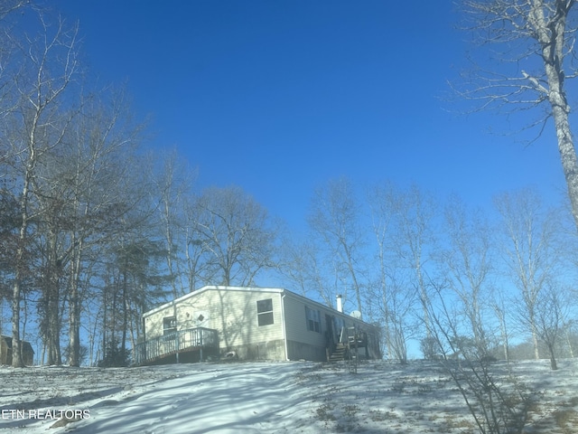 snow covered property featuring a wooden deck