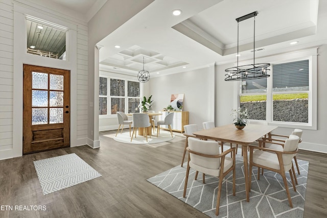 dining area with crown molding, plenty of natural light, a tray ceiling, and dark hardwood / wood-style flooring