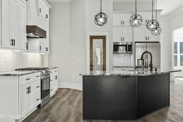 kitchen with pendant lighting, white cabinets, light stone counters, a kitchen island with sink, and stainless steel appliances