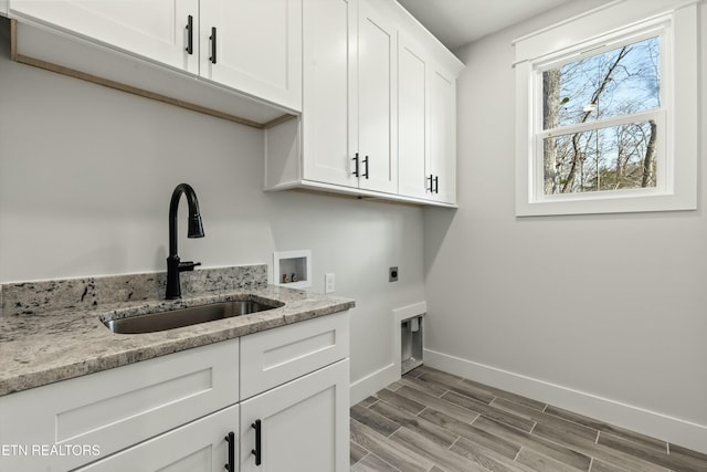 washroom featuring cabinets, electric dryer hookup, light hardwood / wood-style floors, sink, and hookup for a washing machine