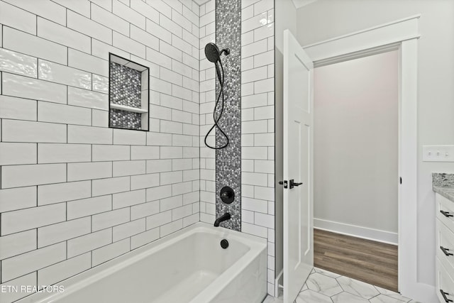 bathroom featuring vanity and tiled shower / bath