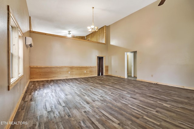 interior space featuring high vaulted ceiling, dark hardwood / wood-style floors, ceiling fan with notable chandelier, and a wall mounted air conditioner