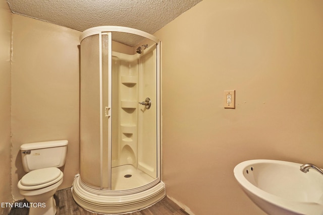 bathroom featuring wood-type flooring, sink, a textured ceiling, and walk in shower