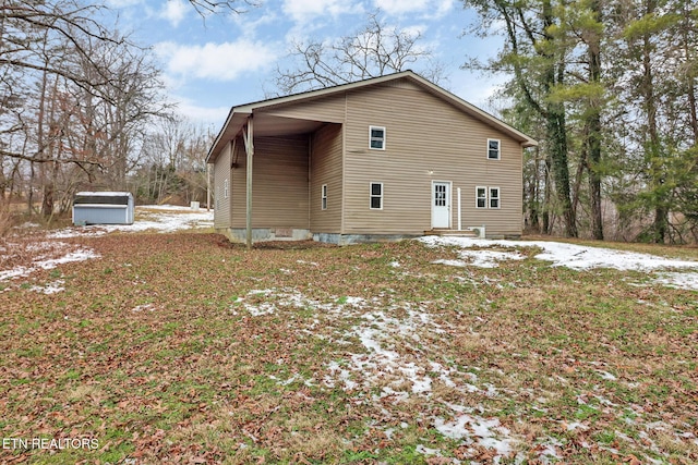 rear view of house featuring a storage unit