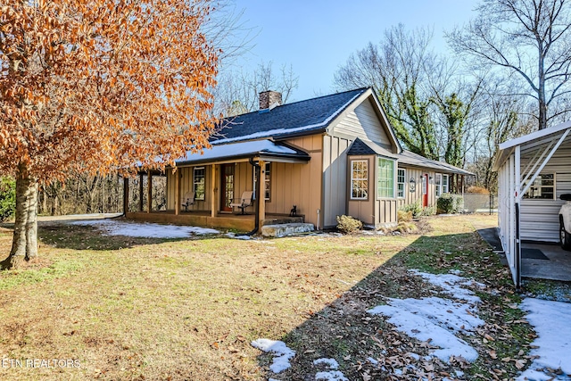 view of side of home featuring a porch and a lawn