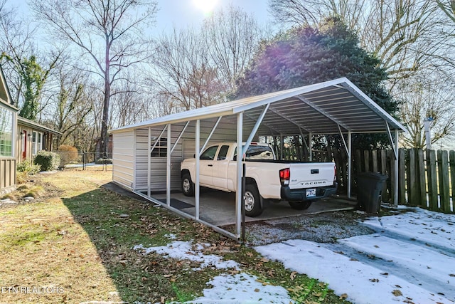 snow covered parking featuring a carport